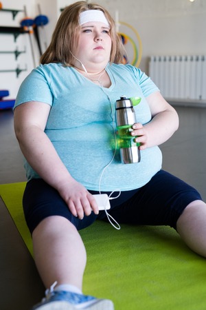 Tired Obese Woman Sitting on Matの写真素材