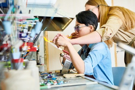 Two Female Artists Collaborating in Glassworking Studio