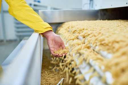Female Hand Catching Spilling Macaroniの写真素材