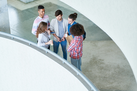 Young international students talking in university lobbyの写真素材