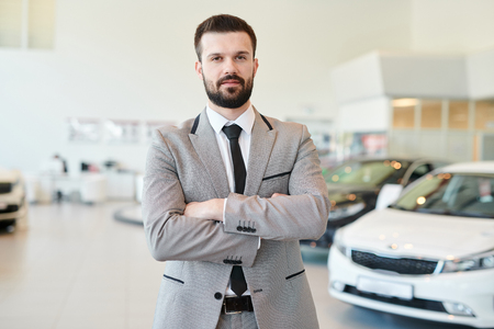 Mature Businessman Posing in Car Showroomの写真素材
