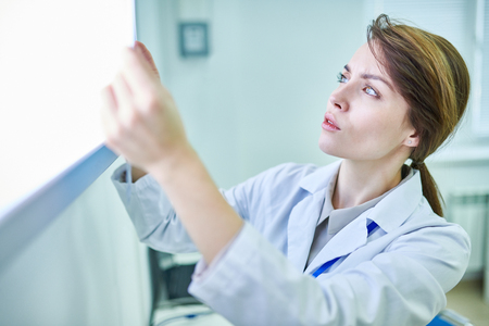 Doctor holding something and examining itの写真素材