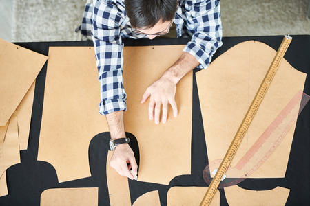 Man applying dress patterns on textile