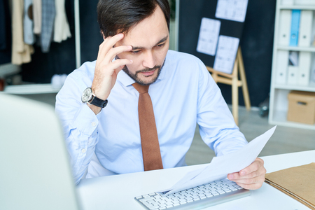 Brainstorming man reading papersの写真素材