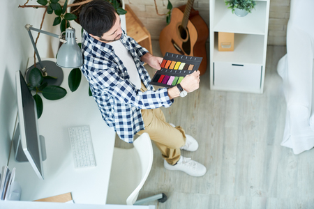 Thinking man working with color choice in officeの写真素材
