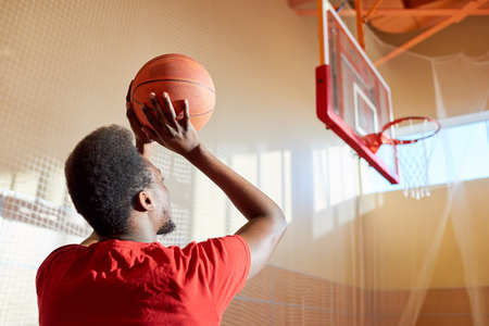 Black man throwing basketball ballの写真素材