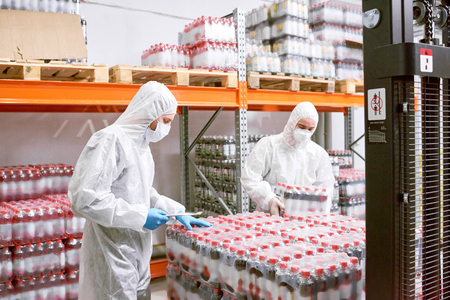 Factory employees unloading packs of bottlesの写真素材