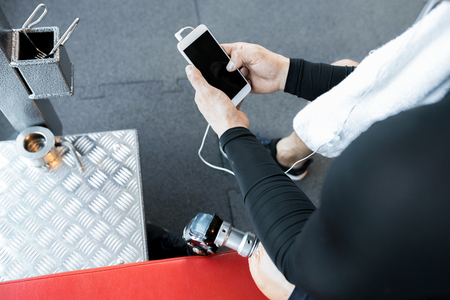 Unrecognizable Adaptive Athlete Using Smartphone in Gymの写真素材