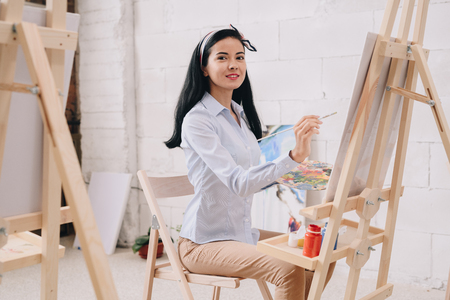 Young Woman Painting at Easelの写真素材