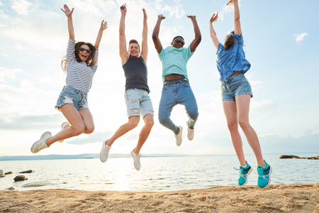 People jumping on the beachの写真素材