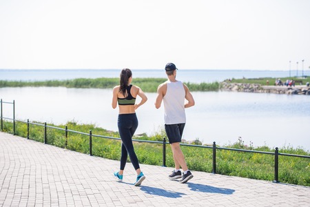 Young Couple Jogging by Lakeの写真素材