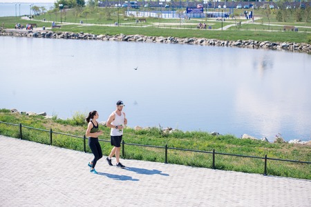 Couple Jogging in City Park Backgroundの写真素材