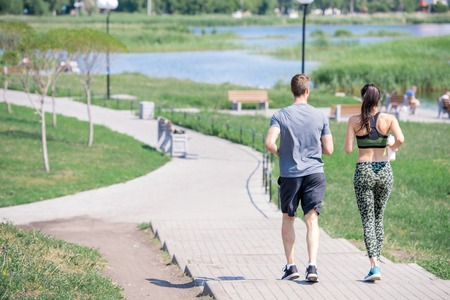 Back View of Couple Running Outdoorsの写真素材