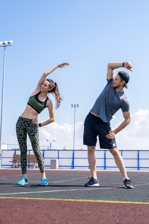 Young Couple Stretching on Track