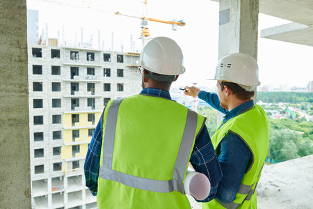 Constriction workers discussing building structureの写真素材