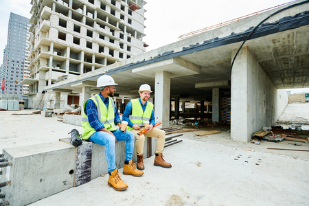 Positive builders relaxing on construction siteの写真素材