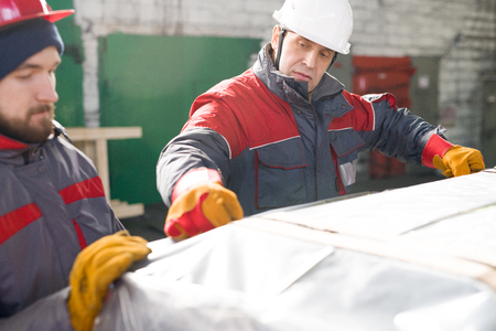 Workers Wrapping Loads in Warehouseの写真素材