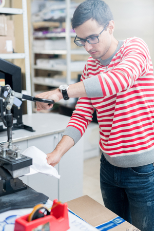 Man making print on cap with pressの写真素材