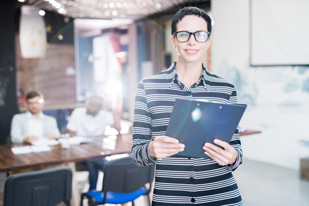 Smiling female manager with clipboardの写真素材