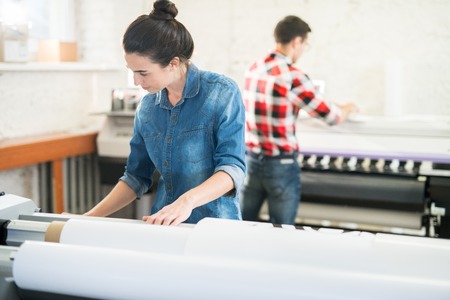 Concentrated woman working in printing officeの写真素材