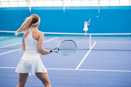 Two Girls Playing Tennis in Courtの写真素材
