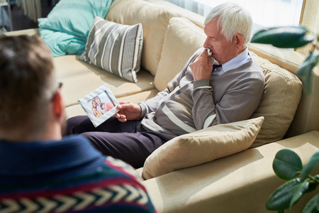 Despaired man sharing his family problems with psychiatristの写真素材