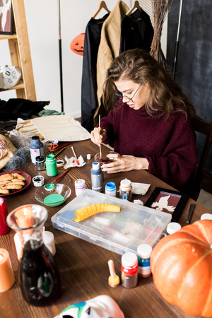 Busy girl in glasses mixing paints in workshopの写真素材