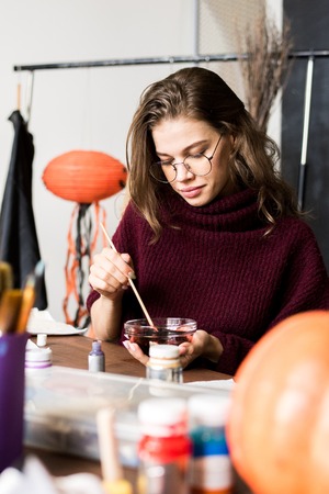 Creative artist mixing paint in bowlの写真素材