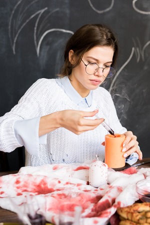 Concentrated girl working on Halloween decorationの写真素材