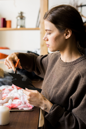 Young lady making paper decor for Halloweenの写真素材