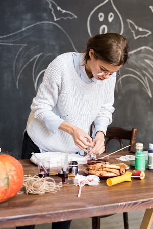 Woman drawing up liquid paint in syringeの写真素材