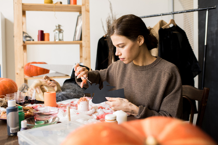 Serious craftswoman making Halloween decorationの写真素材