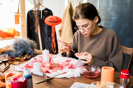 Concentrated craftswoman adding paint on toy jawの写真素材