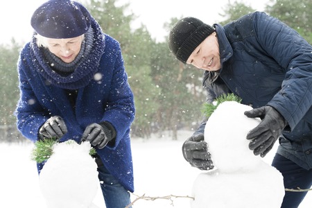 Senior Couple Building Snowman