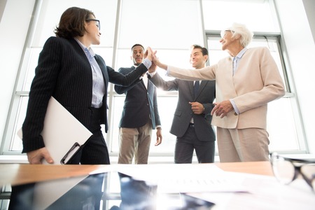 Successful business team giving high five in officeの写真素材
