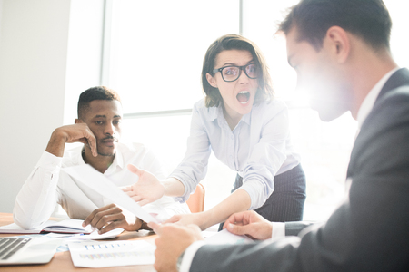 Furious lady boss shouting at subordinate at meetingの写真素材