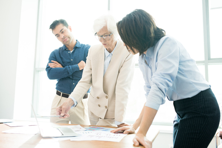 Confident senior businesswoman presenting data to colleaguesの写真素材