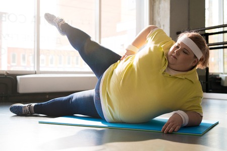 Obese Young Woman Working Out in Sunlightの写真素材