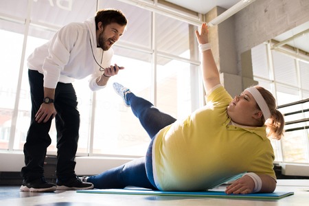 Obese Young Woman Working Out with Coachの写真素材