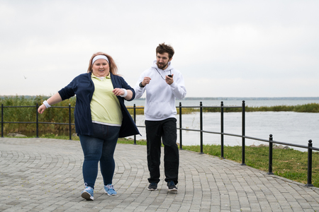 Obese Woman Running in Parkの写真素材