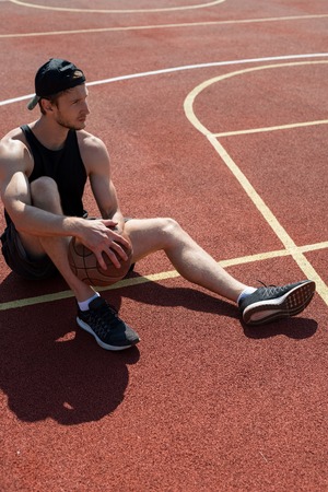 Handsome Young Man Resting in Basketball Court