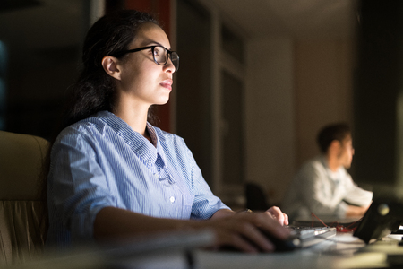 Hispanic Woman Working at Nightの写真素材