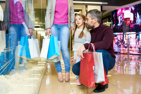 Little Girl Shopping with Parentsの写真素材