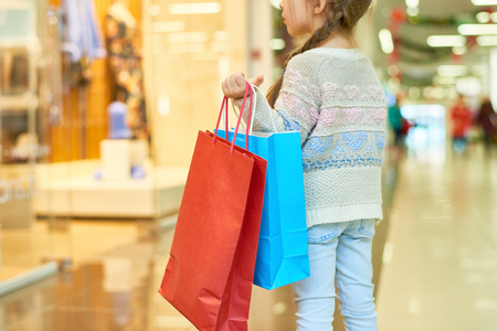 Cute Little Girl Holding Shopping Bagsの写真素材