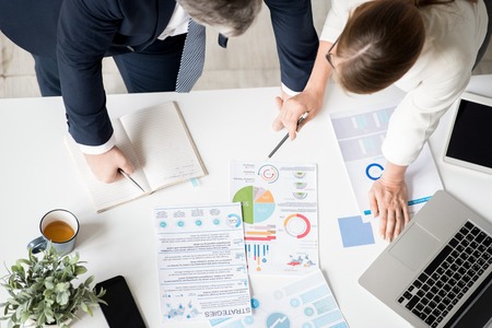 Business partners examining data report togetherの写真素材