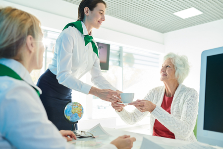 Taking care of client in travel agency officeの写真素材