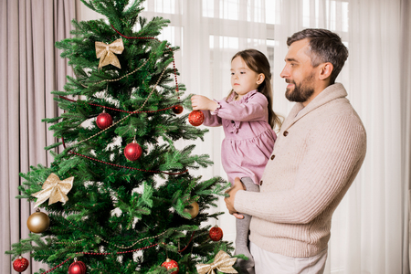 Father and Daughter Decorating Treeの写真素材