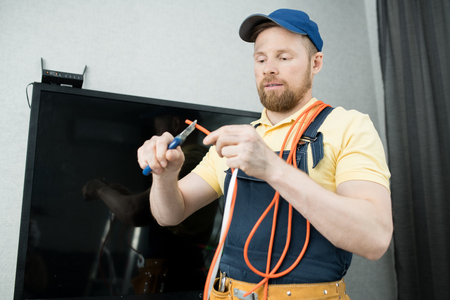 Electrician stripping wire in flatの写真素材