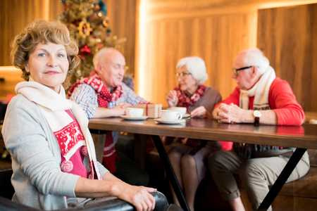 Content senior lady in cafe with friendsの写真素材