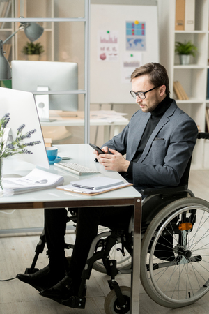 Disabled businessman using smartphoneの写真素材